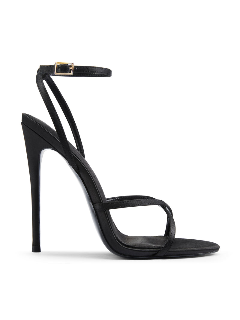 Femme LA Ale Sandal in Satin Black – side profile showing crossed thin toe straps, ankle strap with gold buckle, and slim stiletto heel