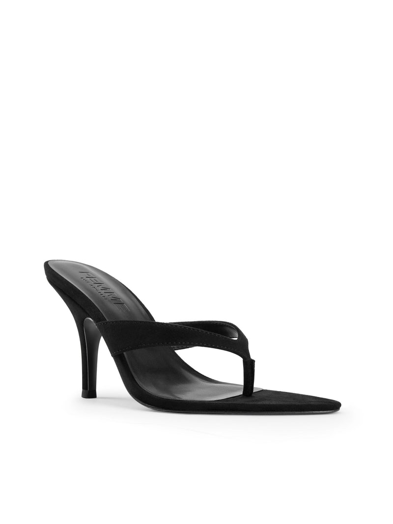 FEMME LA Tokyo Thong Sandal in Noir — front three-quarter view showing thong toe post, black suede strap, and slim stiletto heel